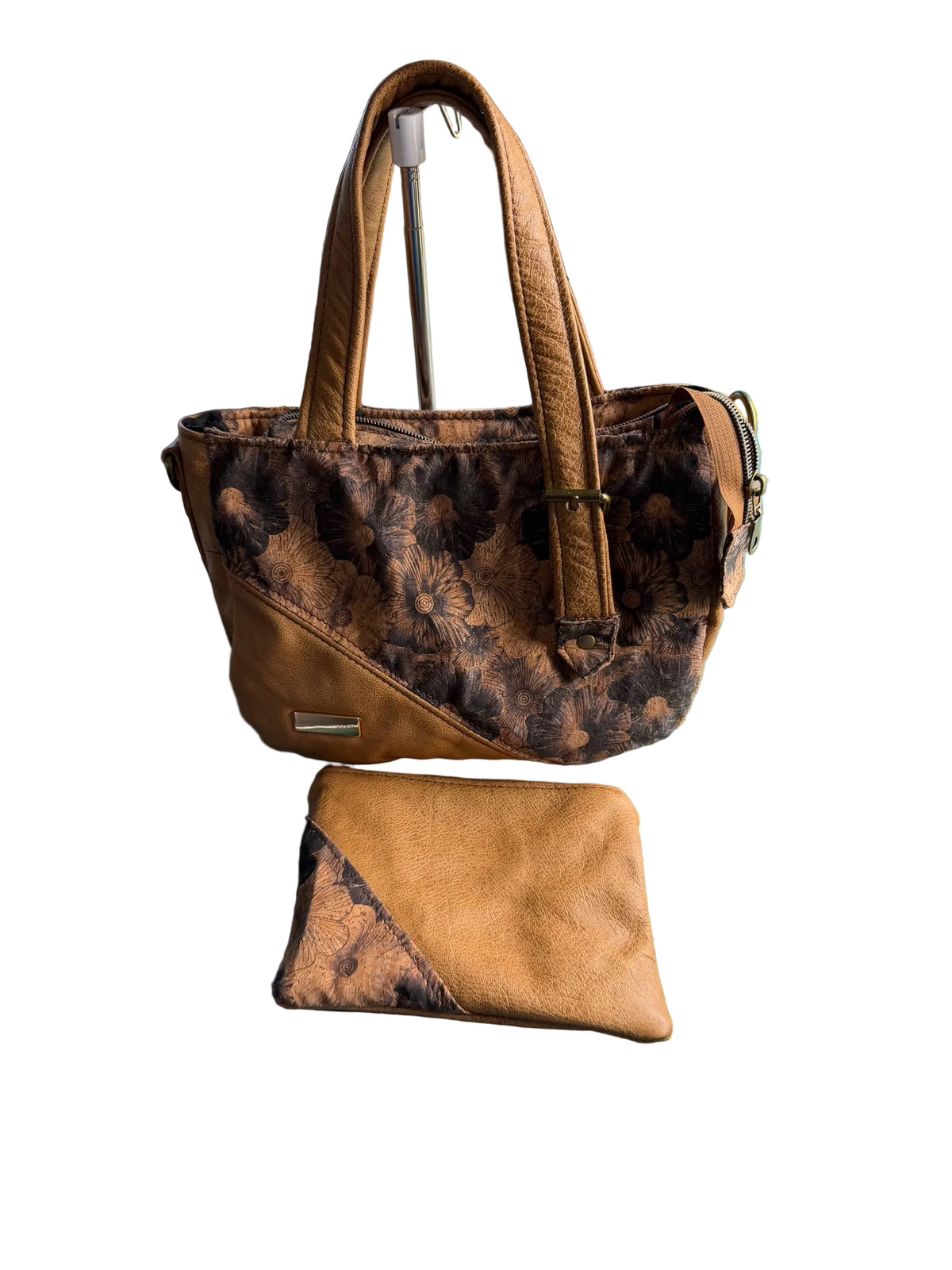Lacarmenbags tan faux leather handbag with dark floral fabric accents and a matching accessory pouch on a craft mat.